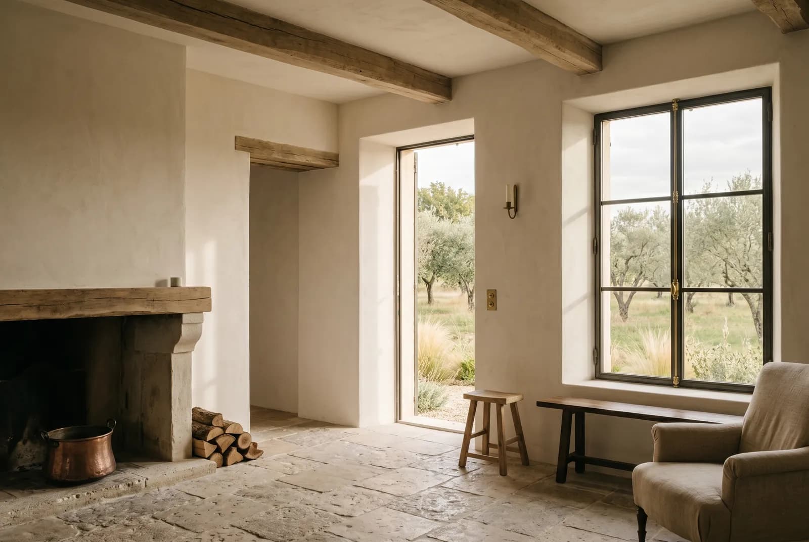 Restored Provençal farmhouse interior — lime plaster, weathered oak, stone floor, and a tall window onto an olive orchard beside a quiet hearth.
